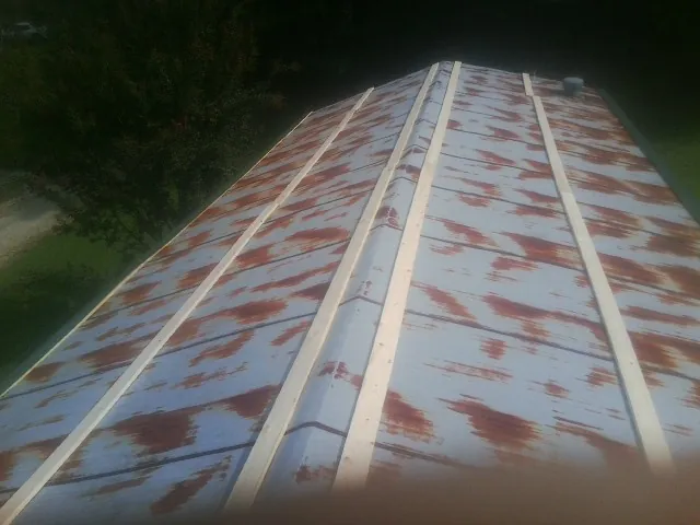 Rusted metal roof panels with new wood purlins before replacement — Storm Damage Roof Repair in Falconer by Roofing Brothers