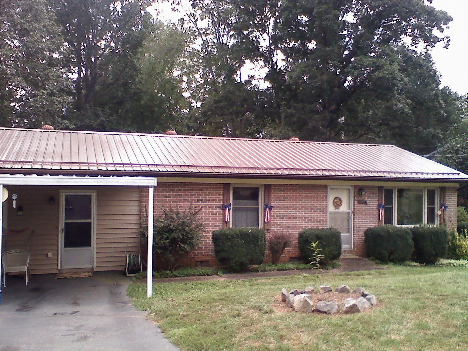 Bronze metal roof and carport on a brick ranch home — Roof Repair work by our crew in Falconer